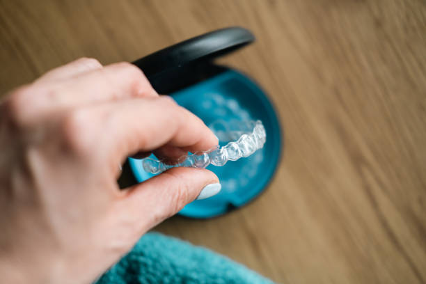Woman's hand holding Invisalign tray