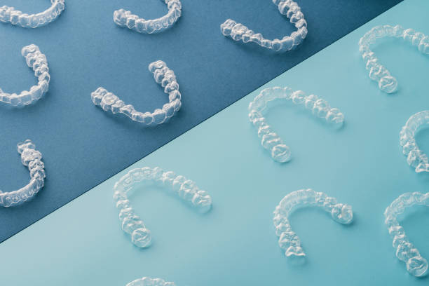 multiple Invisalign laid out on a two-toned surface