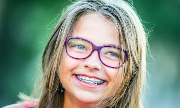 a young girl smiling with braces