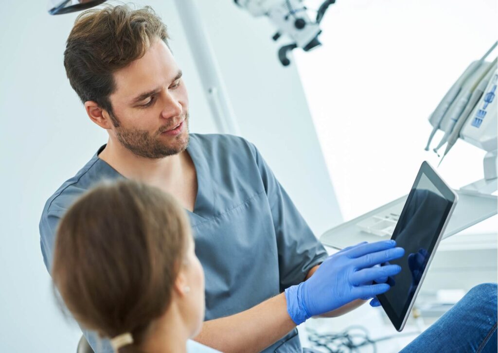 Orthodontist explaining a treatment plan for correcting an overbite with braces during a patient consultation.