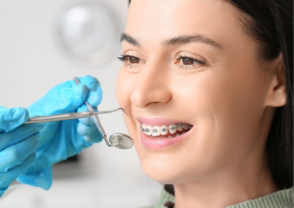 Orthodontist examining a patient with braces during treatment to monitor progress in correcting an underbite.