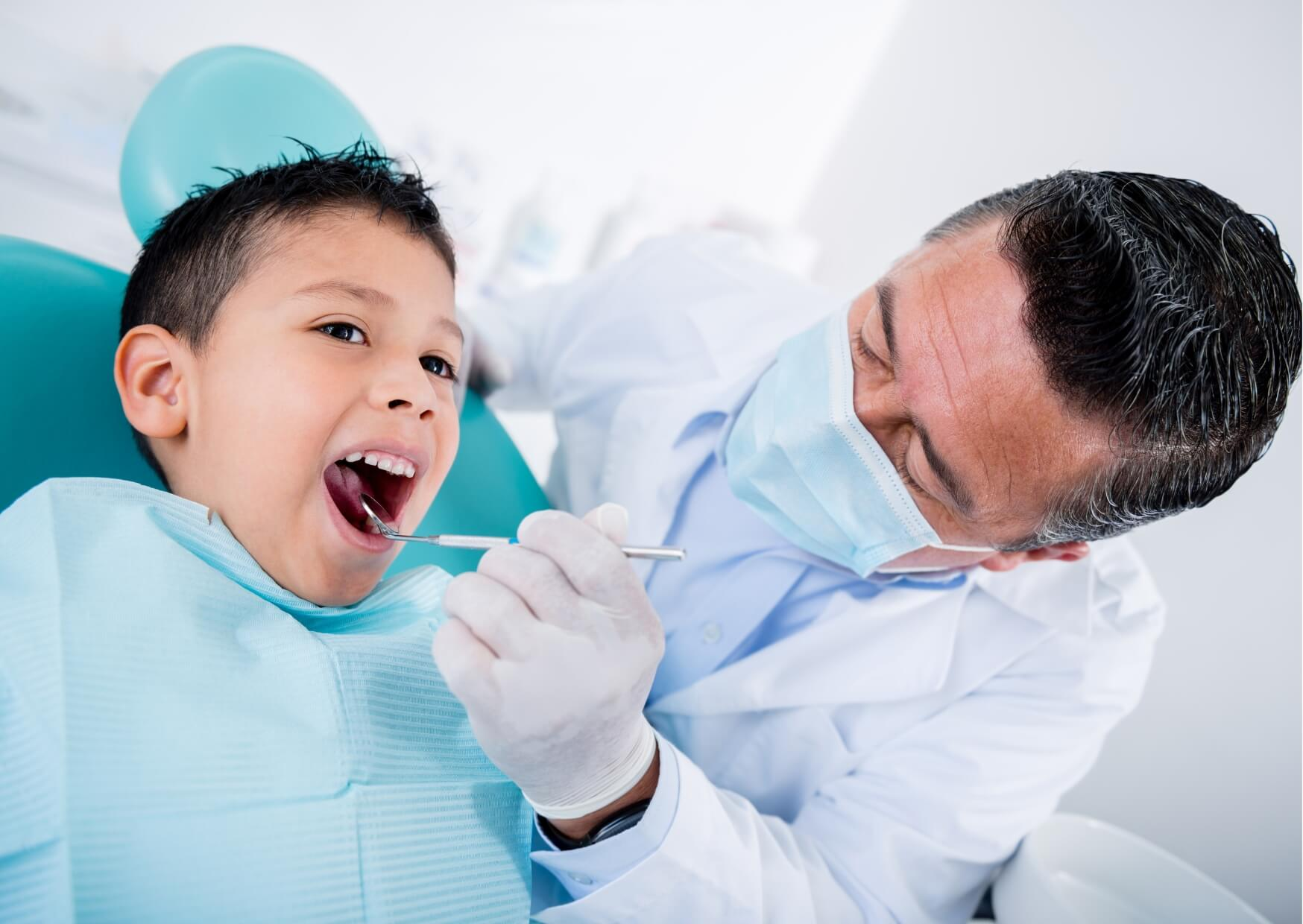 Dentist examining a child's teeth during an appointment to evaluate whether a dental spacer is needed after early tooth loss.