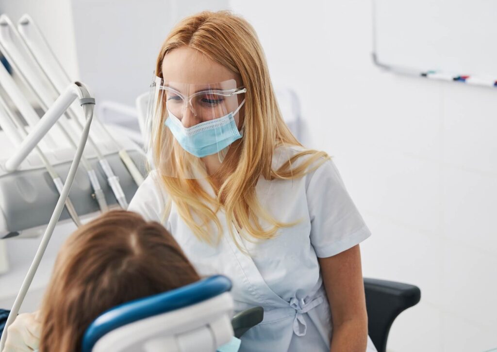 Orthodontist discussing treatment options with a patient during a consultation about whether clear braces are the right choice.