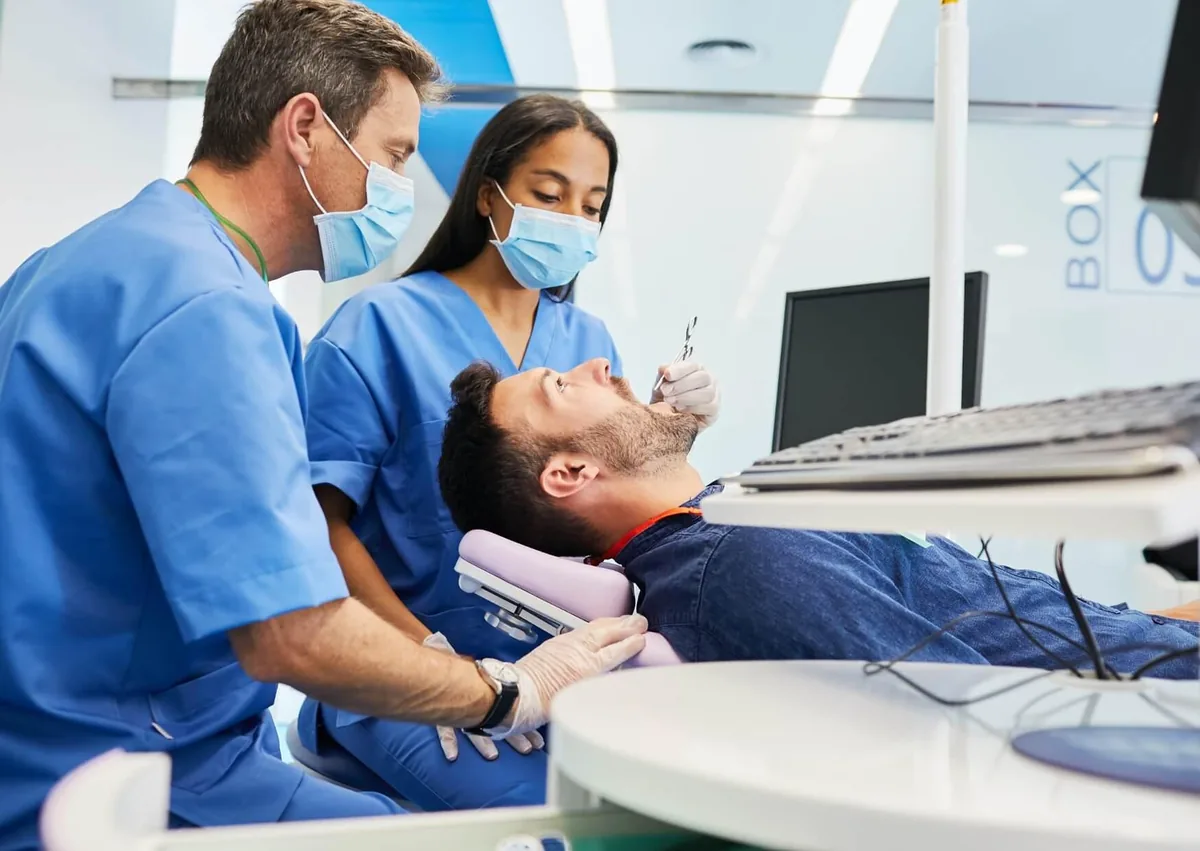 Orthodontic team examining a patient before using a palate expander as preparation for braces.