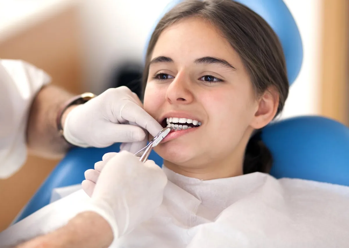 Orthodontist adjusting a child’s braces during an orthodontic appointment.