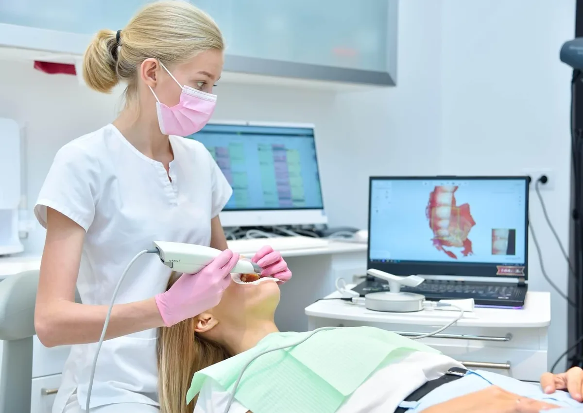 Dentist using digital scanning technology to evaluate a patient for open bite correction.